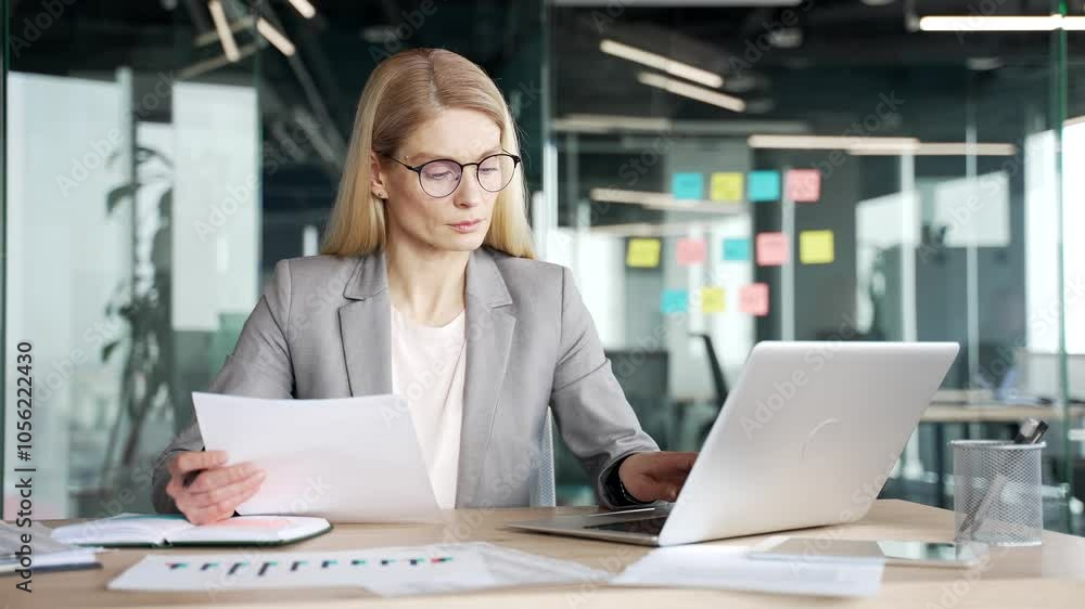 Happy businesswoman satisfied with financial results sitting at workplace in office. Smiling female financier looks at documents and computer, rejoices at positive indicators, celebrates success Happy businesswoman satisfied with financial results sitting at workplace in office. Smiling female financier looks at documents and computer, rejoices at positive indicators, celebrates success