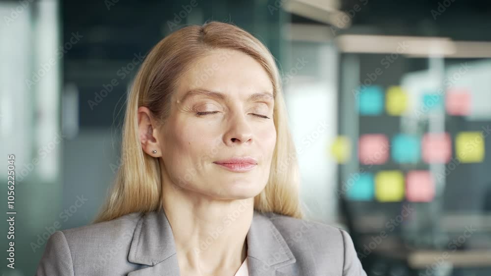 Close up of a businesswoman in a suit relaxing with her eyes closed while sitting at a workplace in a business office. Calm happy female entrepreneur resting in a break at work breathing deeply Close up of a businesswoman in a suit relaxing with her eyes closed while sitting at a workplace in a business office. Calm happy female entrepreneur resting in a break at work breathing deeply