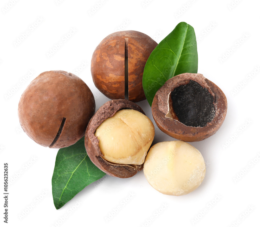 Macadamia nuts and green leaves on white background, top view Macadamia nuts and green leaves on white background, top view