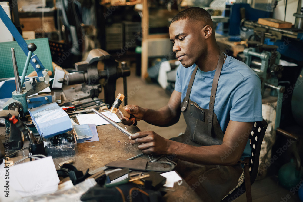 Male craftsperson making jewelry while sitting on chair at workshop Male craftsperson making jewelry while sitting on chair at workshop