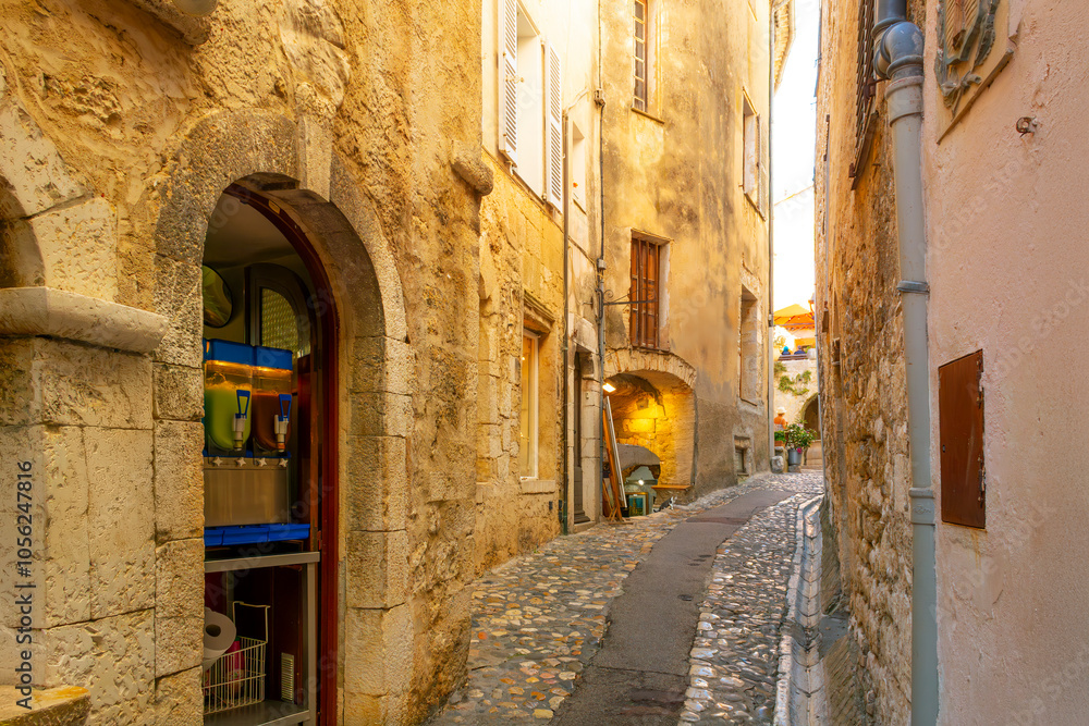 Obraz premium One of the many narrow cobblestone walkways, streets and paths of shops and cafes in the hilltop medieval village of Saint-Paul de Vence, France.