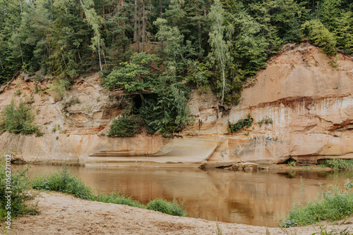 Rred sandstone "Devil's cave" cliffs(latvian: Velnalas klintis) on Gauja river in Sigulda, Latvia at Summer