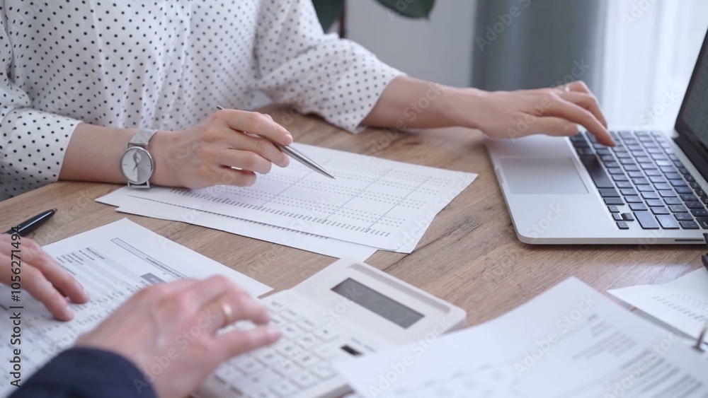 Bookkeeper woman is working with a colleague, using magnificent glass, calculator and laptop. Audit and taxes concept Bookkeeper woman is working with a colleague, using magnificent glass, calculator and laptop. Audit and taxes concept