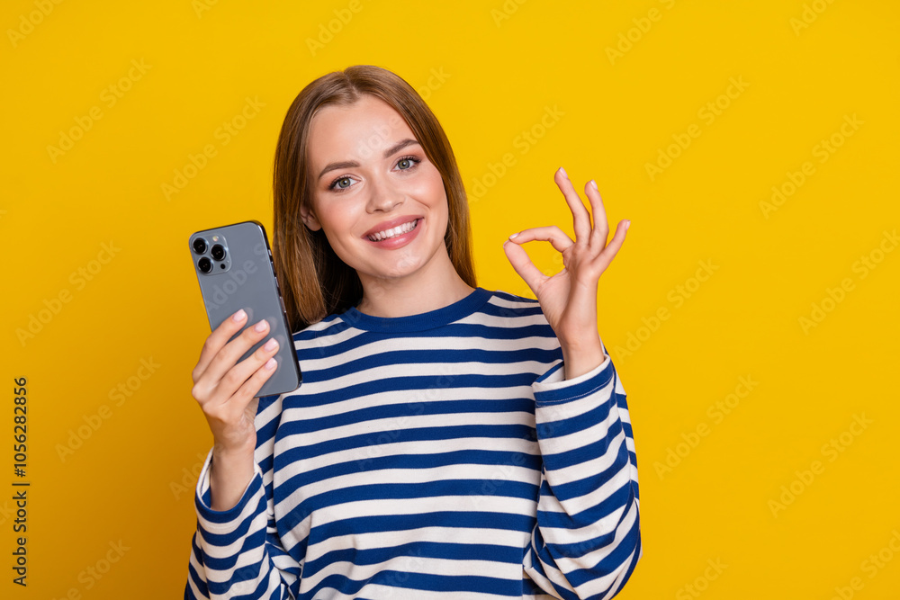 Photo of charming adorable cute woman wear striped stylish clothes okey sign isolated on yellow color background Photo of charming adorable cute woman wear striped stylish clothes okey sign isolated on yellow color background