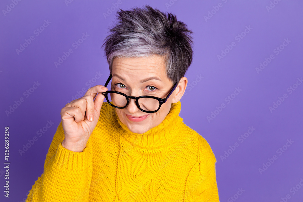 Fototapeta premium Stylish mature woman with glasses in yellow sweater on purple background