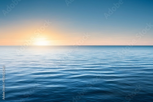 The ocean is calm and the sun is setting, creating a beautiful