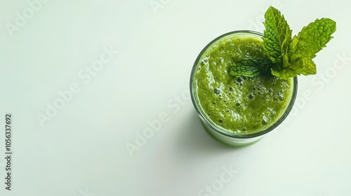 A refreshing avocado smoothie in a glass, garnished with mint, set against a bright white backdrop for a refreshing look