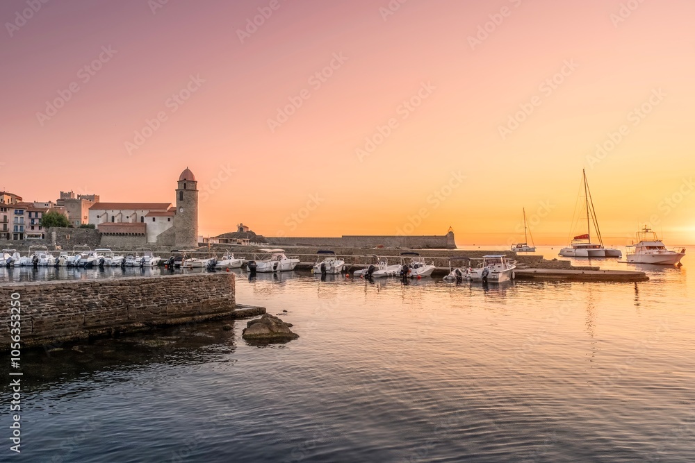 Traditional Catalan Fishing Boats In The Harbor Of The City Of Collioure, With The Church Of Notre-dame-des-anges Visible In The Background, France.