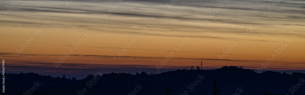 Orange sky with mast and hills in background.
Orange sky with mast and hills in background.