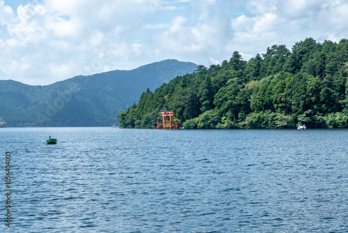 Scenic view of the famous red torii gate at hakone shrine. Reflected in the calm waters of lake ashi photo