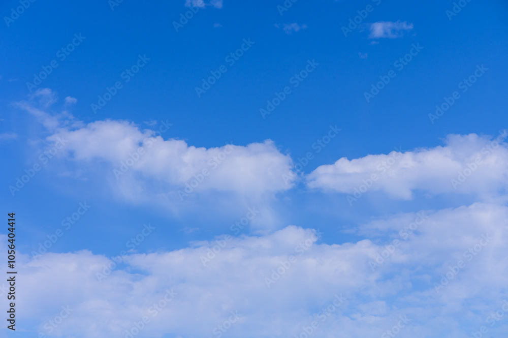 Bright blue sky filled with fluffy white clouds drifting peacefully on a sunny day Bright blue sky filled with fluffy white clouds drifting peacefully on a sunny day