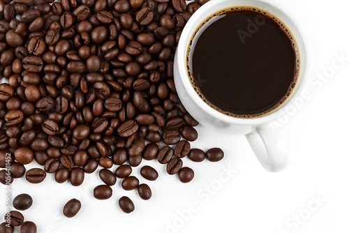 Cup of black coffee next to scattered coffee beans on a white background.