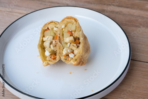 Wallpaper Mural Indonesian pastel sliced open, revealing a warm filling of egg, potato, carrot, and glass noodles—evoking homestyle comfort on a simple white plate Torontodigital.ca