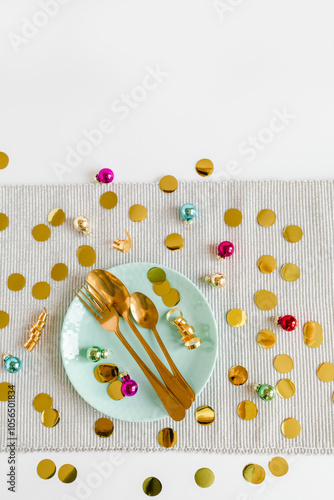 Christmas decoration, flat lay. Christmas table place setting. Golden cutlery, porcelain plate, fir tree branches, toys and golden confetti. Holidays background. Flat lay, top view