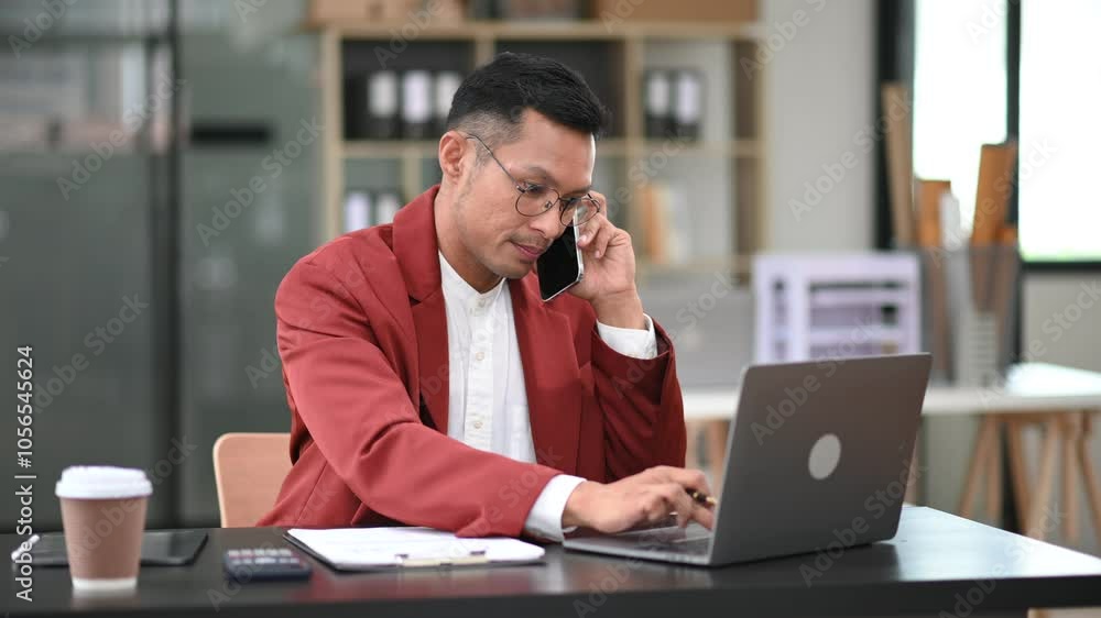 Young man using laptop and tablet while sitting at her working place. Concentrated at work. Young man using laptop and tablet while sitting at her working place. Concentrated at work.
