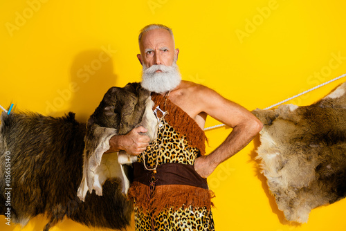 Photo of strong serious cave human wear leoprad skin showing power emtpy space isolated yellow color background photo