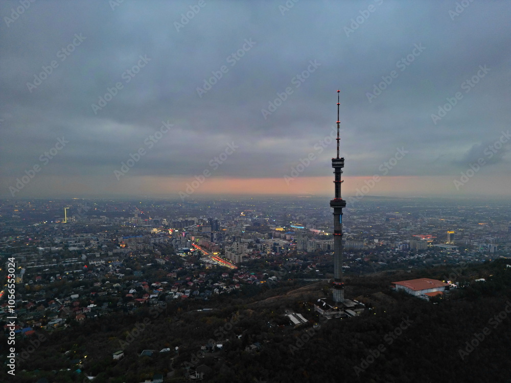 Obraz premium Koktobe TV tower on the hill after sunset. View of the city. Cloud cover. Autumn.