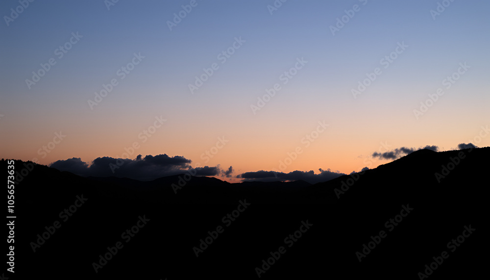 Silhouettes of mountains with a crescent moon and soft clouds, capturing the calmness of a peaceful night. Silhouettes of mountains with a crescent moon and soft clouds, capturing the calmness of a peaceful night.