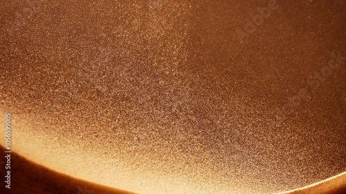 Golden sand particles flowing in slow motion. Abstract macro shot. 