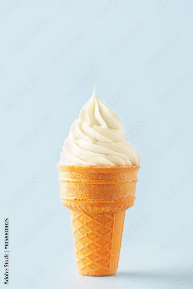Vanilla soft ice cream ball in a waffle cone on a blue background Vanilla soft ice cream ball in a waffle cone on a blue background