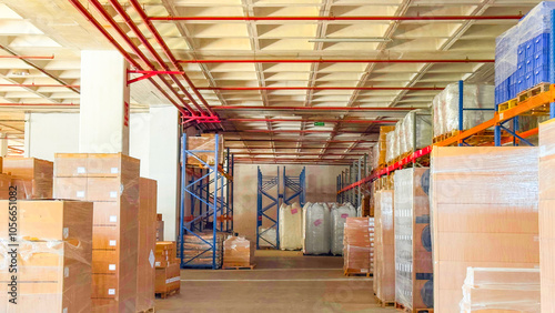 Spacious warehouse interior with stacked boxes and shelves, organized for storage and distribution in an industrial setting.

