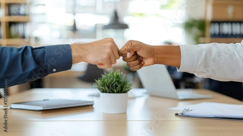 Closeup of colleagues fistbumping over desk, shared achievement, neutral modern office decor, team spirit, photorealism, camaraderie
