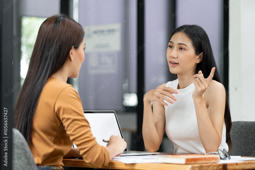 Business women at office desk working together on a laptop, teamwork concept Business women at office desk working together on a laptop, teamwork concept
