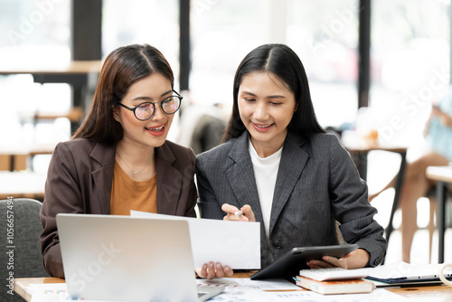 Business women at office desk working together on a laptop, teamwork concept