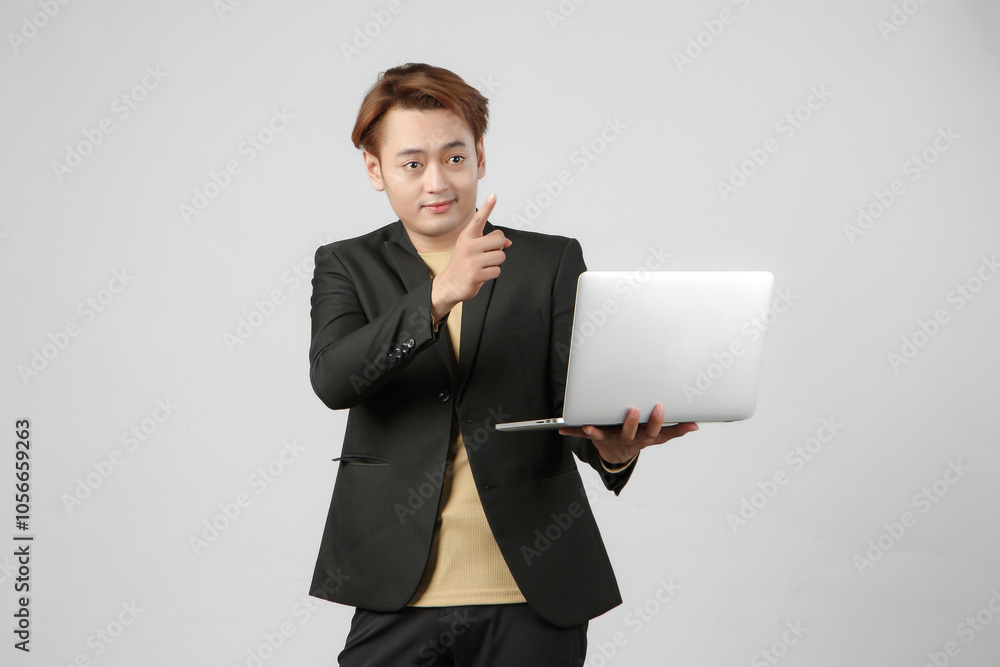 portrait of happy asian businessman holding laptop computer wearing suit with pointing finger gesture on isolated background portrait of happy asian businessman holding laptop computer wearing suit with pointing finger gesture on isolated background