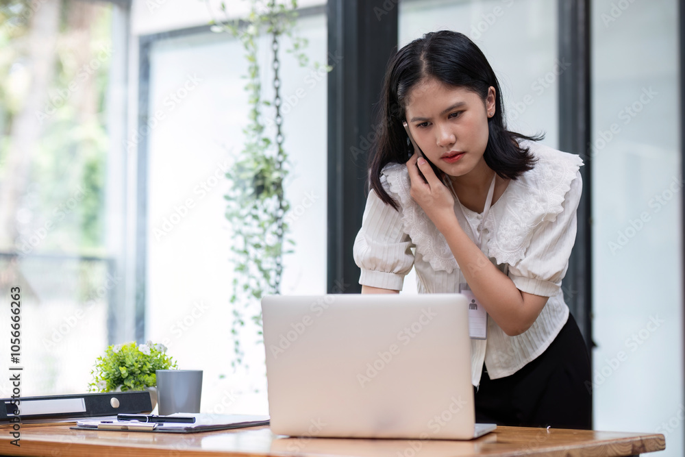 Stressed Business Woman Working at Desk in Modern Office Environment with Laptop and Documents Stressed Business Woman Working at Desk in Modern Office Environment with Laptop and Documents