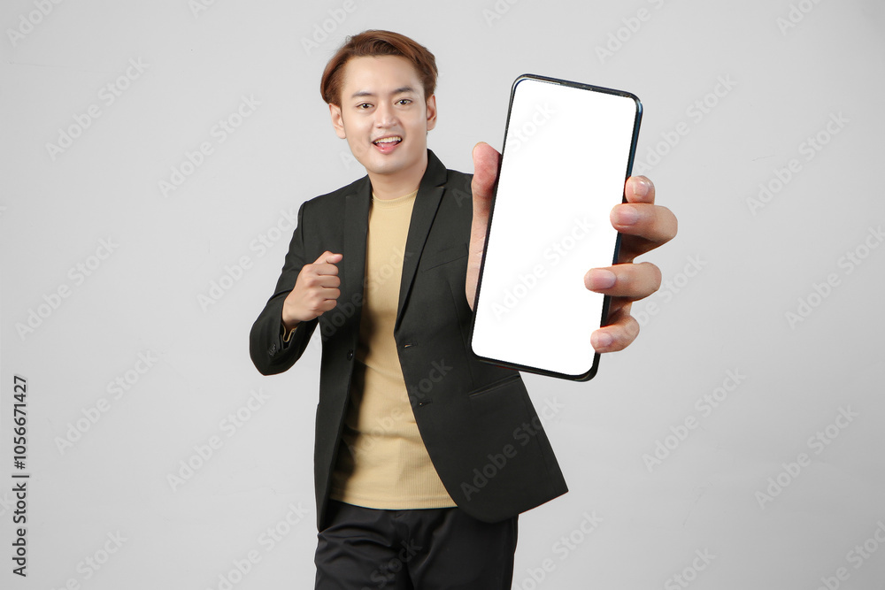 portrait of happy asian businessman wearing suit holding mobile phone and showing blank screen on isolated background portrait of happy asian businessman wearing suit holding mobile phone and showing blank screen on isolated background