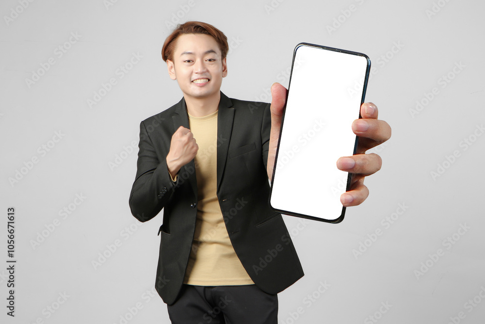 portrait of happy asian businessman wearing suit holding mobile phone and showing blank screen on isolated background portrait of happy asian businessman wearing suit holding mobile phone and showing blank screen on isolated background