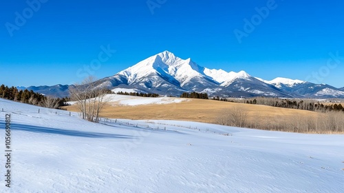 A breathtaking mountain landscape featuring snow-covered peaks, clear blue skies, and a serene winter scene with rolling hills.