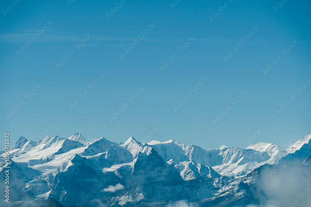 Obraz premium Snowy mountain view under a bright blue sky.