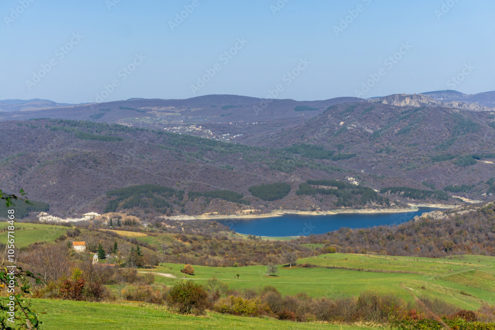 Obraz premium Algeti reservoir between hills and fields. Bright autumn colors of grass and leaves. Hills, mountains and bright sky in the background