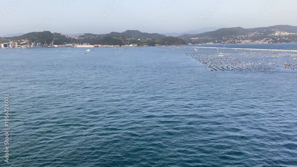 Port of La Spezia, Italy, boat near mussel, fish farms at sea barrier Port of La Spezia, Italy, boat near mussel, fish farms at sea barrier