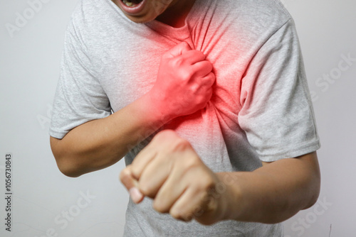 hand hold chest with heart attack symptoms, asian man working hard have chest pain caused by heart disease, leak, dilatation, enlarged coronary heart, press on the chest with a painful expression