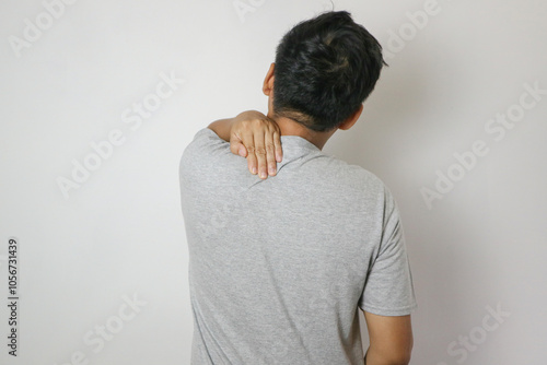 Asian man has problem with structural posture He had neck and back pain. He massaged him neck and shoulders for relief. reduce muscle tension photo