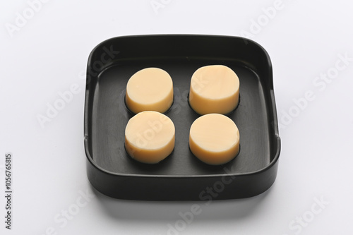 Egg Tofu in black melamine tray on white background.
