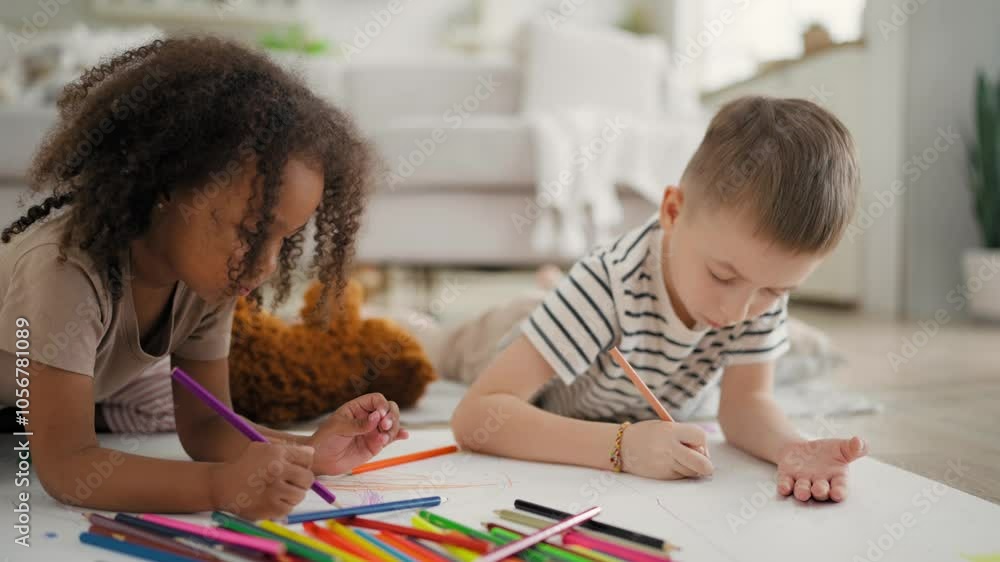Children drawing by crayons, black girl and Caucasian boy, happy childhood. Diverse kinds playing together in living room, friends from early age, children in playroom, happiness and creative hobby Children drawing by crayons, black girl and Caucasian boy, happy childhood. Diverse kinds playing together in living room, friends from early age, children in playroom, happiness and creative hobby