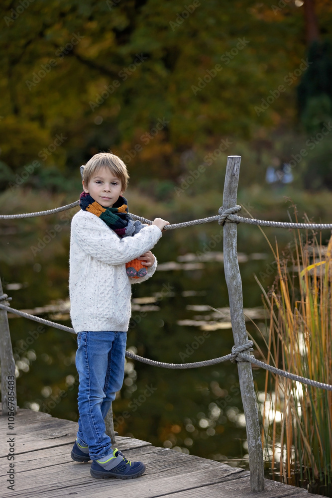 Amazing blond boy, cute child, enjoying a sunny day in Botanical garden in Prague during the halloween exhibition of pumpkins Amazing blond boy, cute child, enjoying a sunny day in Botanical garden in Prague during the halloween exhibition of pumpkins