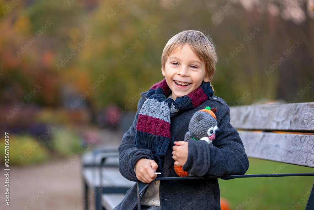 Amazing blond boy, cute child, enjoying a sunny day in Botanical garden in Prague during the halloween exhibition of pumpkins Amazing blond boy, cute child, enjoying a sunny day in Botanical garden in Prague during the halloween exhibition of pumpkins