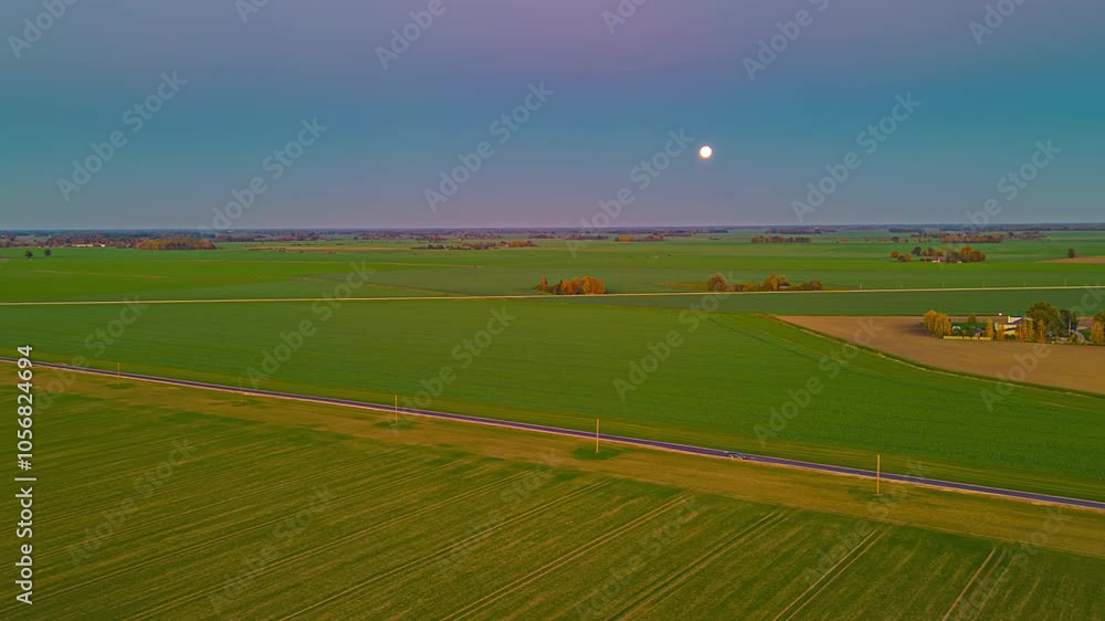 Drone Hyperlapse Capturing Moonrise Above Fields and Rural Road