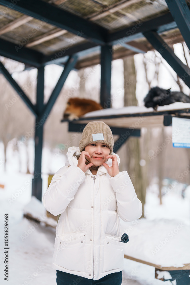 Fototapeta premium Woman tourist with Cute fox on snow in winter season at Zao fox village, traveler sightseeing Miyagi prefecture. landmark and popular for attraction near Sendai, Tohoku, Japan. Travel and Vacation