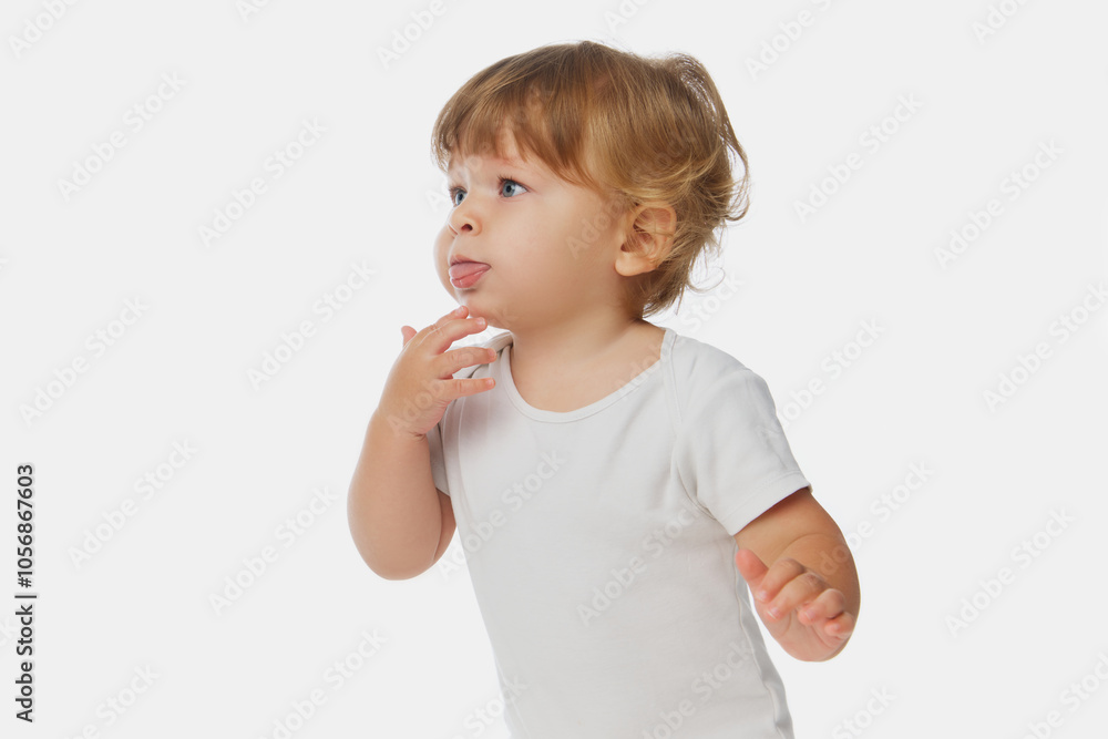 Baby sticking out tongue dressed in white onesie, against white studio background, showing playful side of early childhood. Concept of parenthood, natural beauty, love and care. Ad. Baby sticking out tongue dressed in white onesie, against white studio background, showing playful side of early childhood. Concept of parenthood, natural beauty, love and care. Ad.