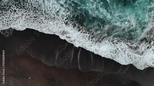 Waves and tide crashing at black sand shore of Pantai Purnama black sand beach, Bali photo