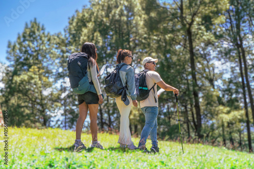 Three Young Friends Hiking in Nature Forest Happy looking for directions Trekking in National Park