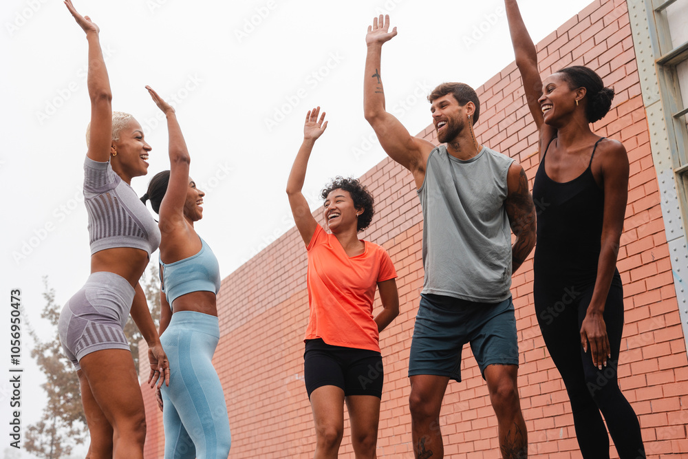 Obraz premium Happy athletes giving high five after successful training in the city