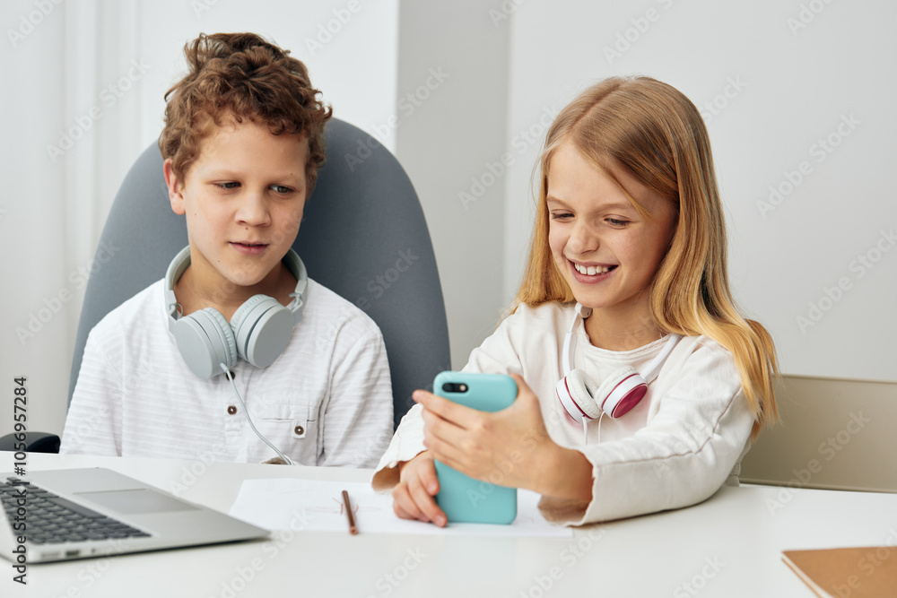 Child Using Laptop for Online Education Happy boy and girl sitting at home in their living room, wearing headphones and studying together on their laptops They are engrossed in the elearning lesson, Child Using Laptop for Online Education Happy boy and girl sitting at home in their living room, wearing headphones and studying together on their laptops They are engrossed in the elearning lesson,