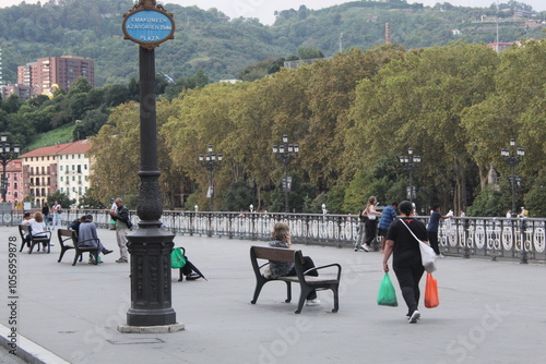 Woman carrying bags that looks like Irish flag in Bilbao